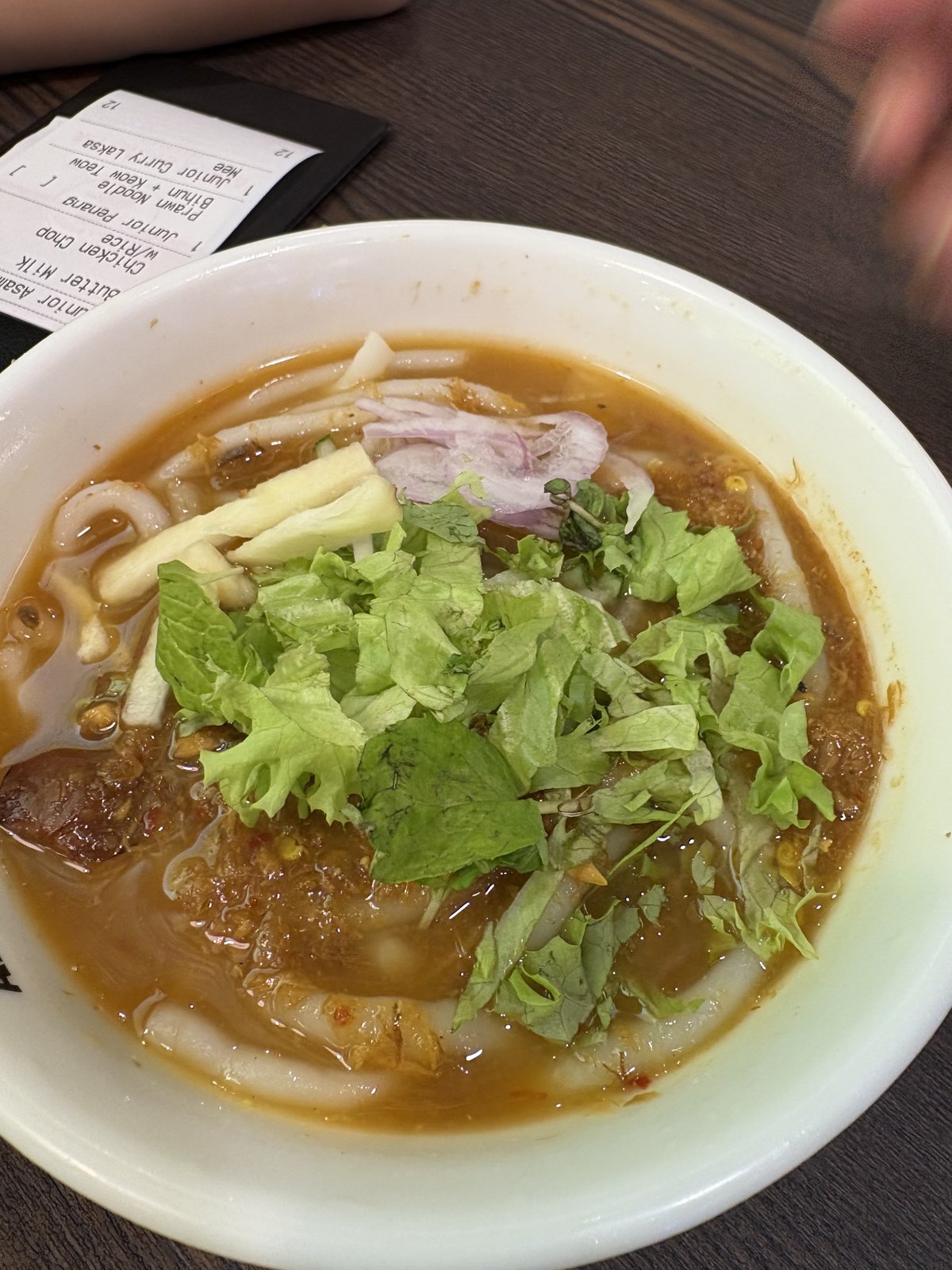 Ah Cheng Laksaで注文したジュニアカレーラクサ(麺)と、背景に写る注文伝票